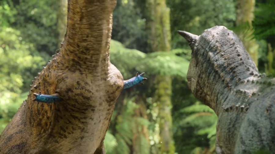 "Prehistoric Planet" screenshot showing the male Carnotaurus standing there with his tiny blue arms, waiting for the female to judge him.